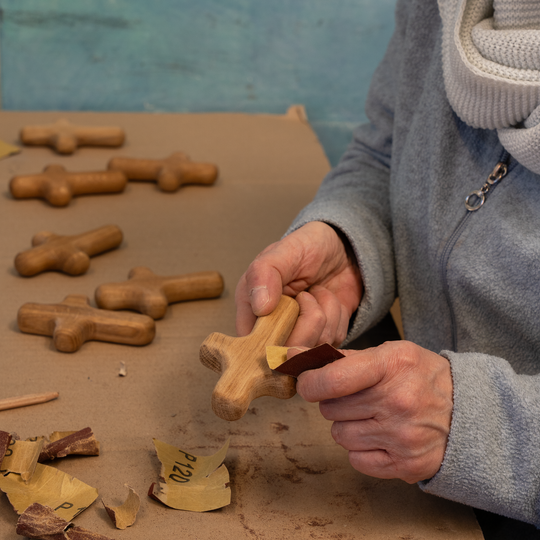 eine Frau hält in der rechten Hand den Handschmeichler und in der linken Hand das Schleifpapier.