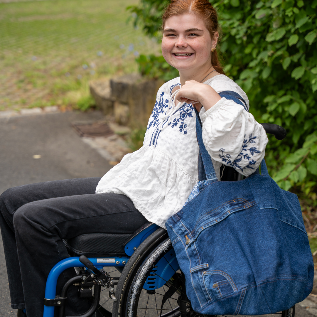 Kuchentasche aus Jeansstoff hängt über Schulter 