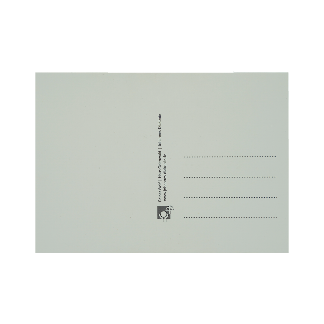 Postkarte von hinten: linke Seite weiß um zu Schreiben, rechte Seite vier Linien für Adresse und Logo und Infos von der Johannes Diakonie.