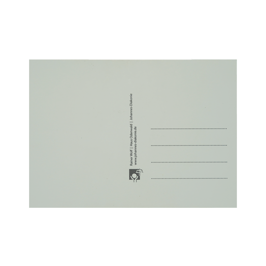 Postkarte von hinten: linke Seite weiß um zu Schreiben, rechte Seite vier Linien für Adresse und Logo und Infos von der Johannes Diakonie.