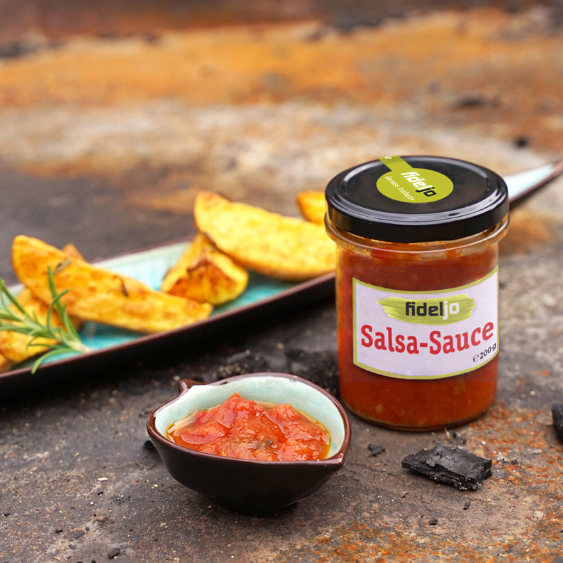 Glas mit Salsa Sauce, Kartoffelecken in einer Schale